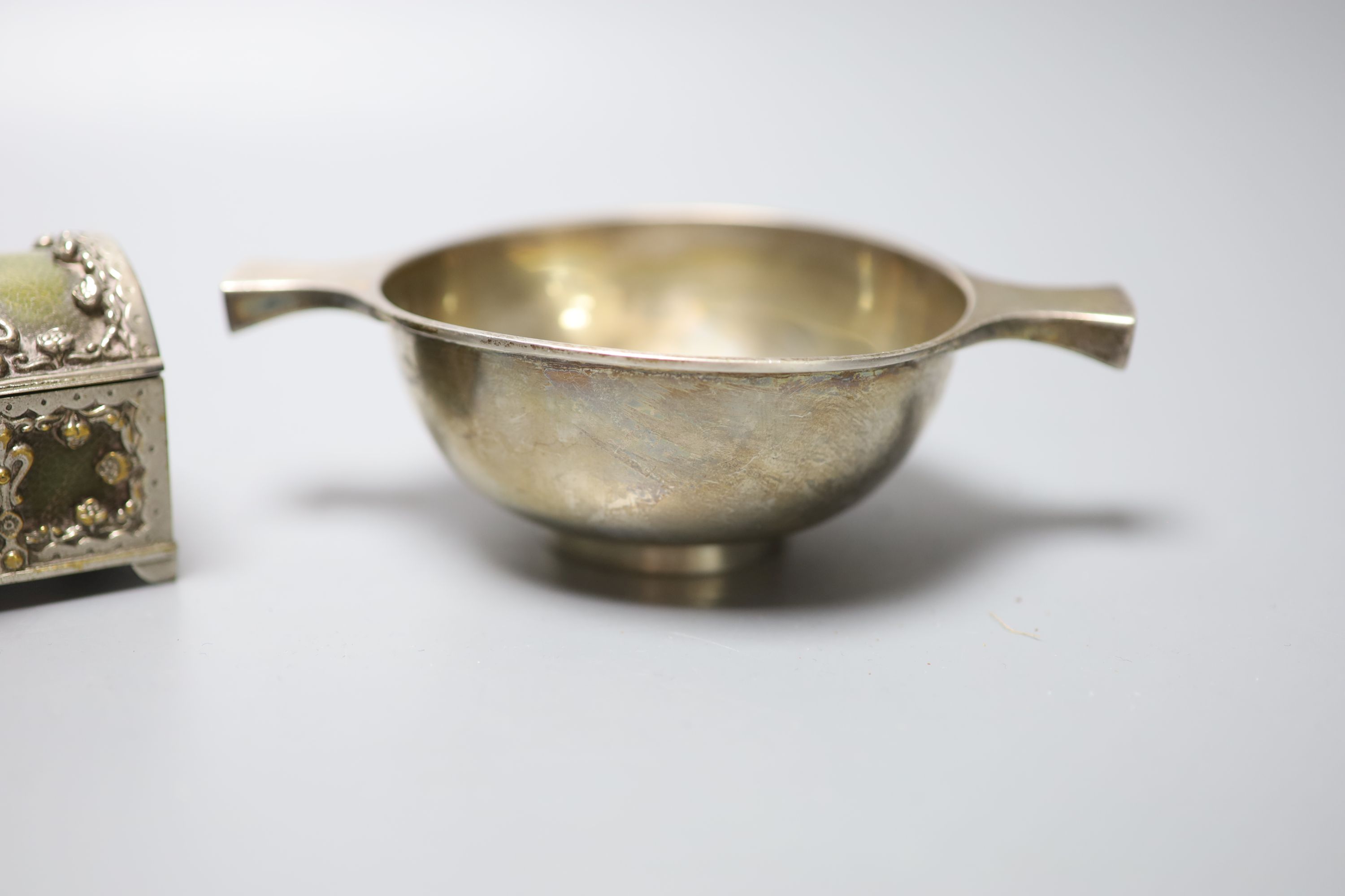 A George V Scottish silver quaich, Edinburgh, 1934, 15.3cm, a plate mounted leatherette casket, two white metal caddy spoons, etc